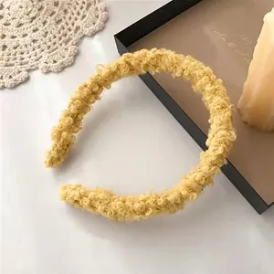 Close-up of ginger yellow lamb wool headband on a white lace and tray setting