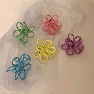 Five candy-colored floral hair claws in pastel tones on a minimalist white background