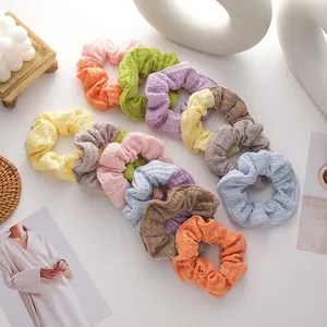 Macro detail of knit waffle texture scrunchies in various pastel macaron colors