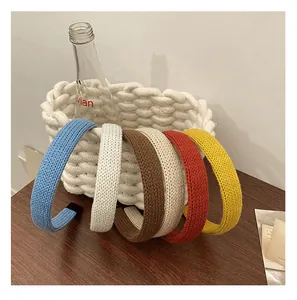 Détail de bandeaux tricotés en cinq couleurs montrant la texture de la maille sur un panier