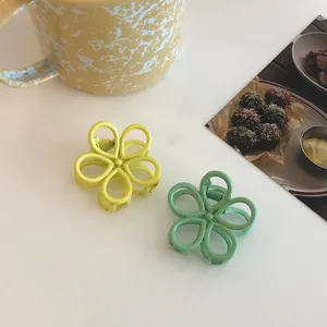 Detail showing matte flower hair claws in pastel lemon yellow and mint green colors