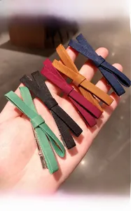 Detailed view of handmade fabric bow hair clips in five colors with metal duckbill clips