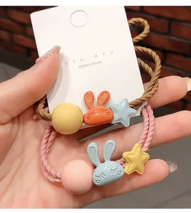 Détail d'élastiques lapin en rose et marron avec étoiles et perles sur carte