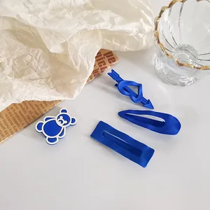 Détail de pinces à cheveux bleu Klein mat avec motif d'ours et design de cœur Love You