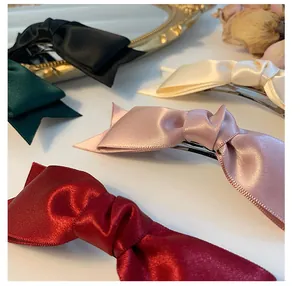 Detailed shot of multi-colored satin bow hair clips in red, pink, white, black and green