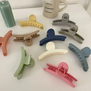 Lot de 9 grandes pinces à cheveux mates aux couleurs acidulées sur une table blanche