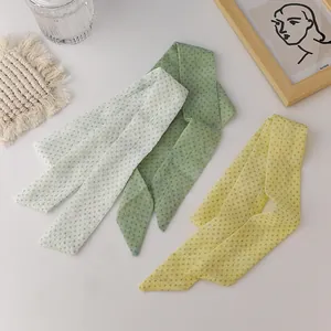 Detailed close-up of three sheer organza polka dot scarves in white, green, and yellow