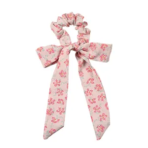 Sweet floral scrunchie with long pink ribbons for a feminine hairstyle look