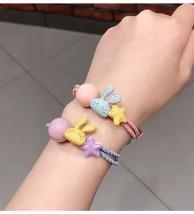 Détail d'élastiques à cheveux avec lapins en résine et étoiles portés au poignet