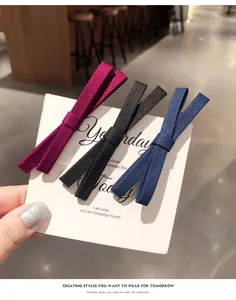 Detail view of bow fabric hair clips in burgundy, black, and navy blue set