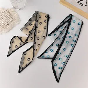 Detail view of sheer organza skinny scarves with smiley face prints and pleated texture