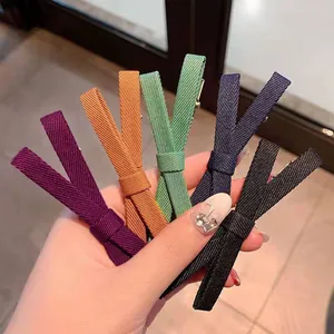 Set of five colorful bow hair clips in purple, orange, green, navy, and black fabric