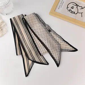 Detail shot of sheer organza scarves featuring elegant black and white stripes and polka dots
