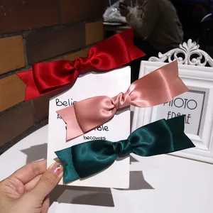 Three elegant French satin bow hair clips in red, pink, and dark green for women