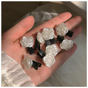 Gros plan détaillé de mini barrettes en forme de roses blanches au fini perlé