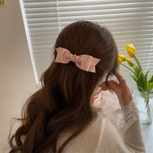 Pink satin bow hair clip for women featuring elegant silk texture in a French style