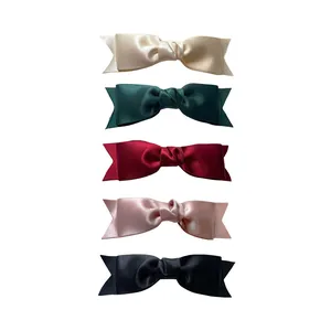 Elegant satin bow hair clips in five colors including black, wine red, and cream white