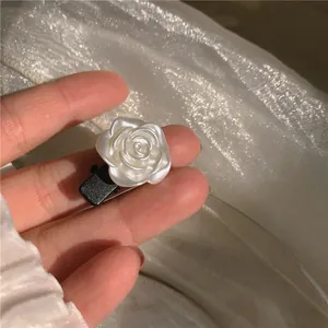 Barrette élégante camélia blanc avec finition résine nacrée sur pince canard en métal