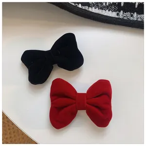 Detailaufnahme hochwertiger Samtschleifen-Haarspangen in Rot und Schwarz mit Textur