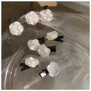 Lot de huit barrettes roses blanches effet perle sur un tissu en maille élégant