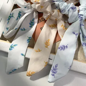 Nahaufnahme von Blumen-Haargummis mit langen Bändern in drei Mustern aus Chiffon-Stoff
