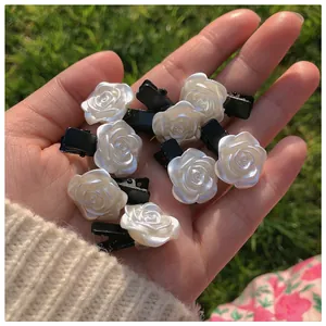 Gros plan de barrettes roses blanches avec éclat nacré sur fond d'herbe verte