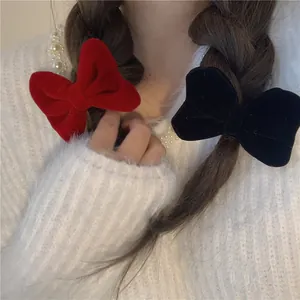 Rote und schwarze Samt-Haarspangen mit Schleifen am Modell für tägliches Frisuren-Styling