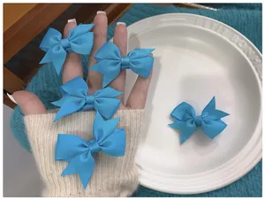Lot de 5 barrettes noeud bleu ciel en ruban gros-grain sur une assiette en céramique
