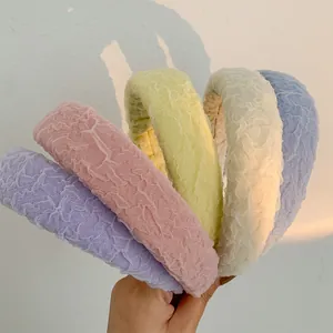 Detailed view of five colorful ruffled mesh headbands in purple pink yellow cream and blue