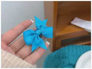 Gros plan d'une pince à cheveux avec nœud en ruban gros-grain bleu vif et design double couche