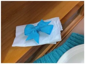 Gros plan détaillé d'une pince à cheveux avec nœud en ruban gros-grain bleu vif sur papier