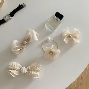Detail of cream tulle bow hair clips set with pearls and crystal rhinestones