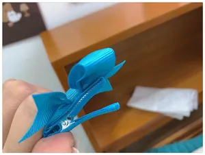Détail d'un nœud en ruban gros-grain bleu vif avec une pince à bec de canard en métal gainé