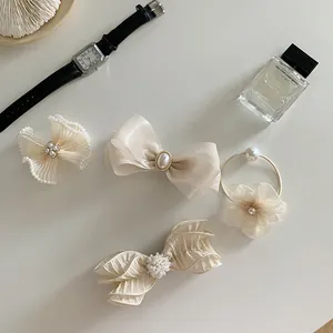 Elegant four-piece cream hair clip set with tulle bows, pearls, and rhinestones