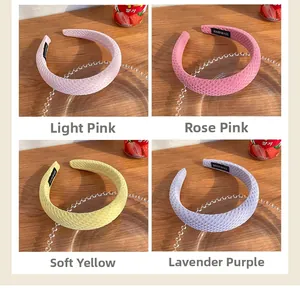 Detail of four candy-colored quilted sponge headbands with handmade label tags