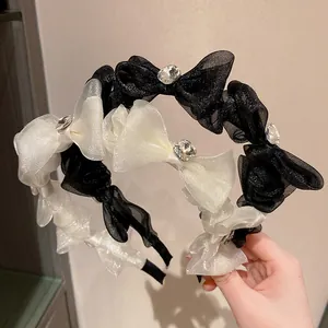 Detail of sheer organza bow headband featuring a large sparkling crystal center