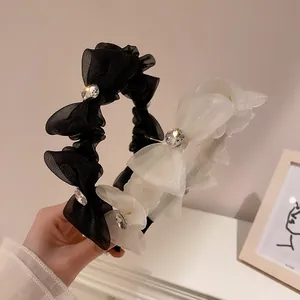Detailed view of layered organza headbands with rhinestones in black and white
