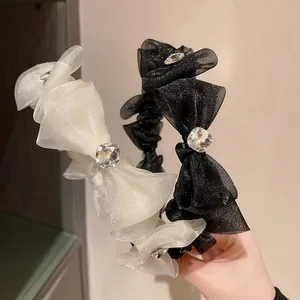 Detail of layered organza bow headband with sparkling crystal centerpiece ornament