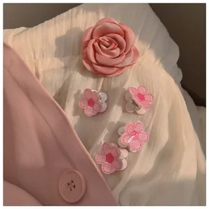 Detail of pink silk rose hair clip and floral mini claw clips with white polka dots