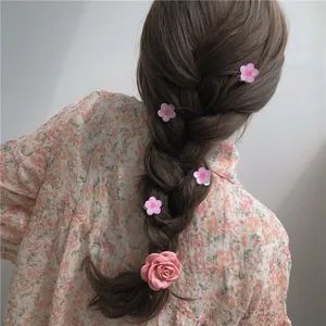 Pink fabric camellia hair clip set styled on braided hair with elegant floral accents