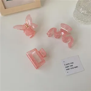 Dettaglio di fermagli per capelli a farfalla rosa lampone traslucidi con trama marmorea