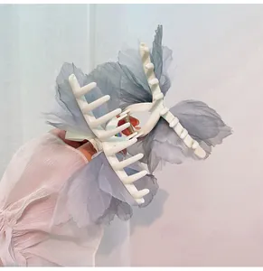 Detalle de pinza grande para el cabello con alas de mariposa en organza azul y brillantes