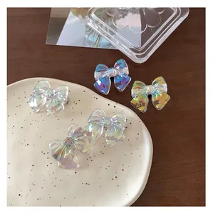 Detailed view of iridescent laser butterfly hair clips with textured finish on a tray