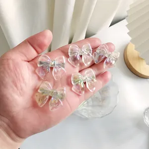 Close-up of five iridescent bow hair clips held in hand to show size and shimmer