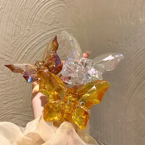 Détail de trois pinces à cheveux papillon en cristal avec design géométrique à facettes