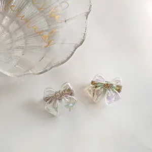 Detail of iridescent mermaid bow hair clips with pastel colors and rainbow gloss finish