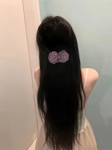 Détail de la pince à cheveux fleur en mousseline lilas sur cheveux longs élégants