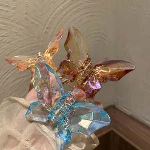 Trois pinces à cheveux papillon en cristal aux reflets bleu, ambre et rose