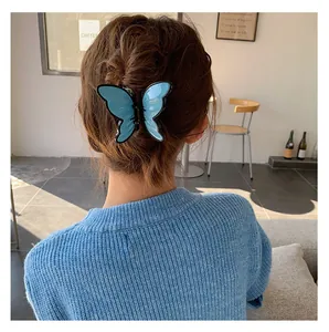 Detail showing the light blue butterfly hair claw clip worn on a low bun hairstyle