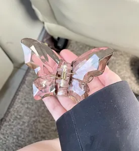 Detail of translucent butterfly hair claw clip with crystal facets and amber resin finish